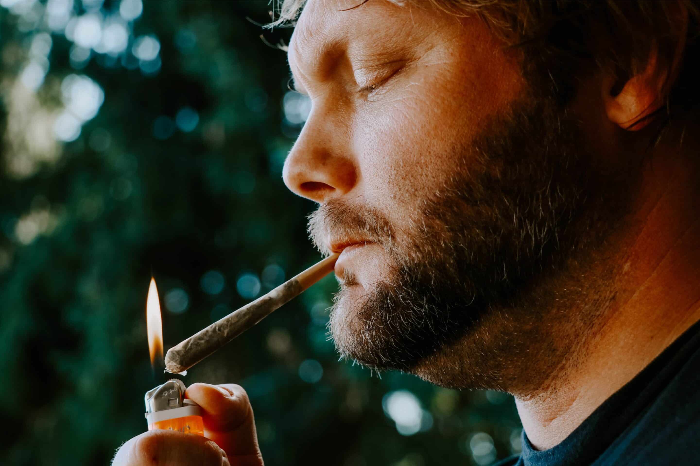 Man lighting a cannabis pre-roll outdoors, illustrating convenience and enjoyment in this pre-rolls guide online.